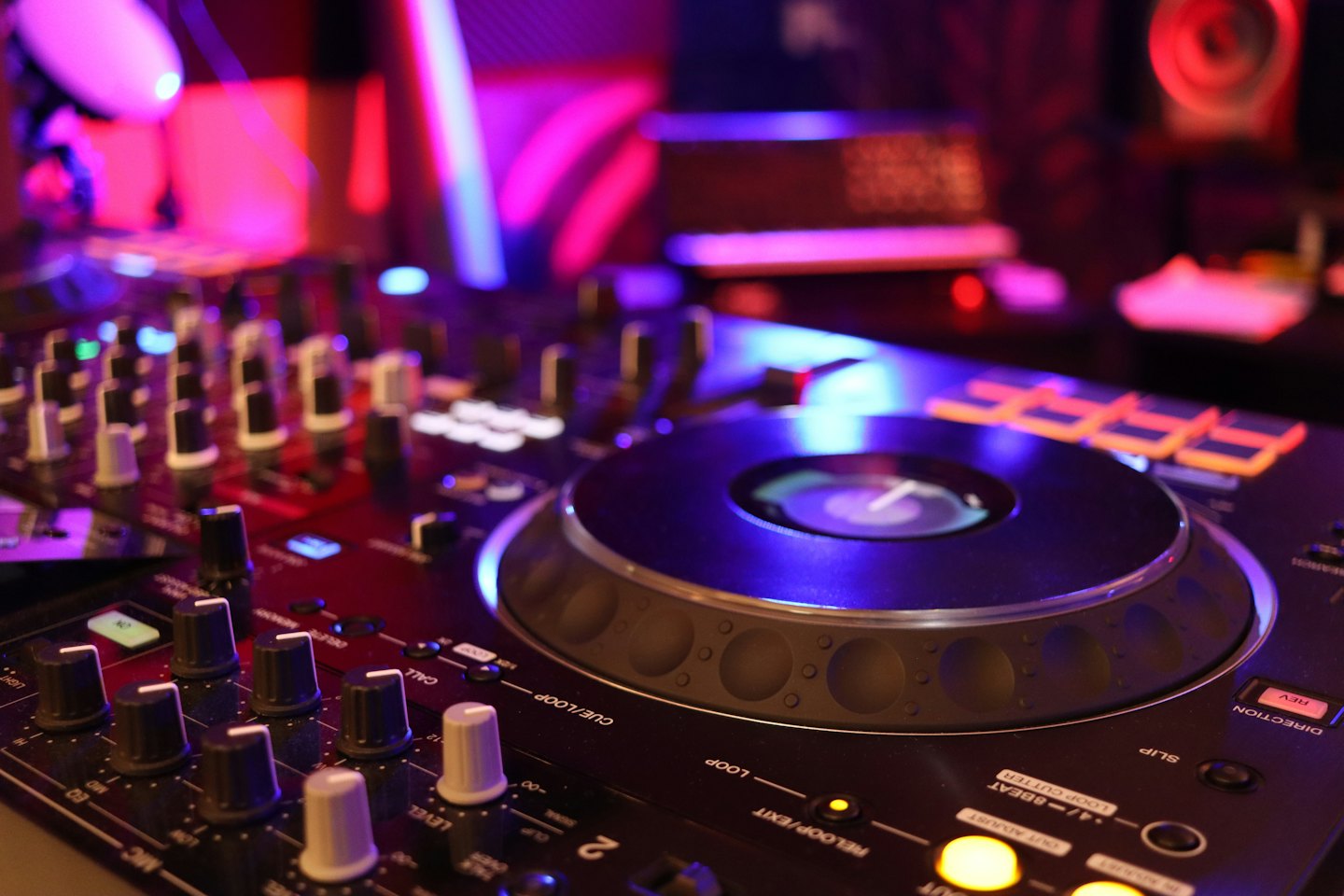 DJ mixing equipment with colorful lights on the jog wheel.