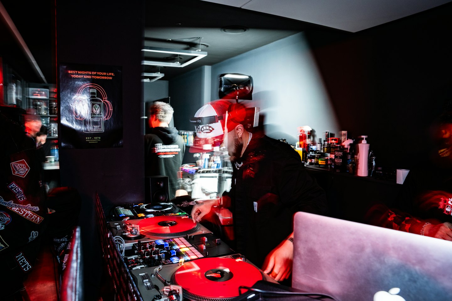 DJ mixing music on turntables and mixer in a club.